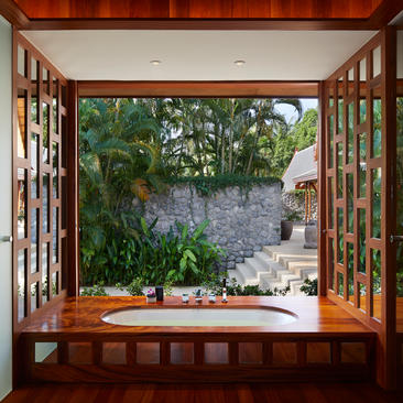安缦璞瑞度假村的木制窗户框架，俯瞰石径花园景观。