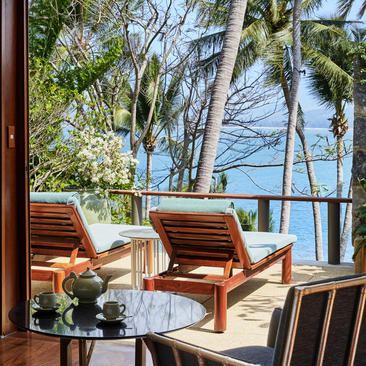 安缦璞瑞度假村的木制躺椅和海景阳台，透过开放式门框眺望。