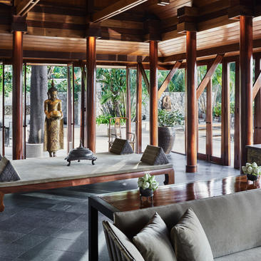安缦璞瑞度假村的开放式客厅，木梁天花板、落地窗框景花园景观。