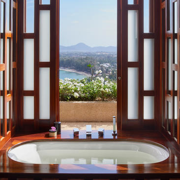 安缦璞瑞度假村别墅浴室，木制门框框住山景，浴缸面向山谷景致。