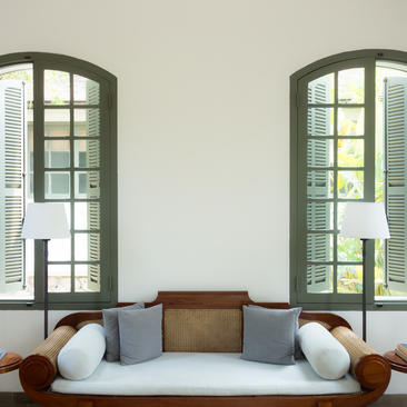 Light-filled seating area at Amantaka with arched windows overlooking the gardens.