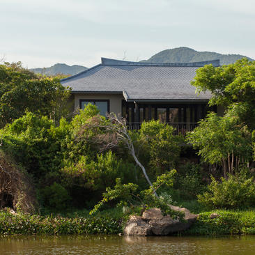 Lake Pavilion at Amanoi, a timber structure surrounded by lush vegetation overlooking water.