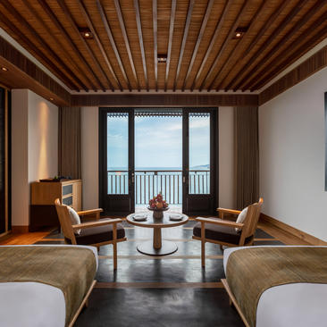 Two beds facing balcony doors with ocean views at Amanoi, Vietnam.