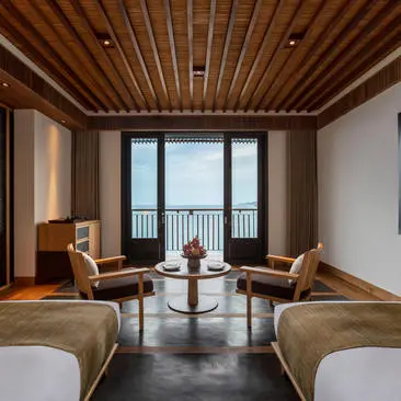 Two beds facing balcony doors with ocean views at Amanoi, Vietnam.