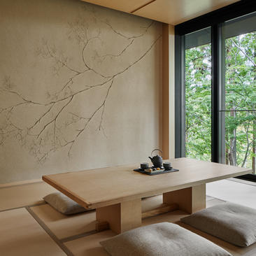 アマン京都のワシガメスイートのリビングルーム。大理石の壁と木製の低いテーブルが配置されている。