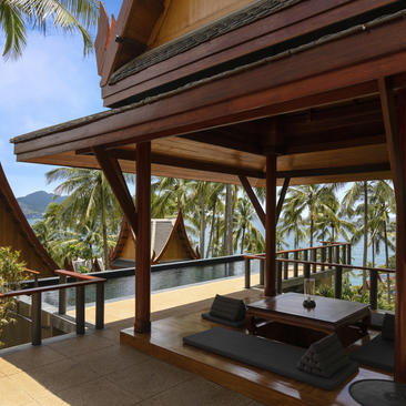 安缦璞瑞度假村的木质露台，配有舒适座位，俯瞰棕榈林。