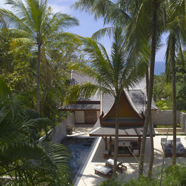 安缦璞瑞度假村中，棕榈树环绕的现代帐篷式建筑，配有木质平台和泳池景观。