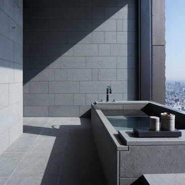 Principal bathroom at Aman Tokyo with stone bathtub and city views.