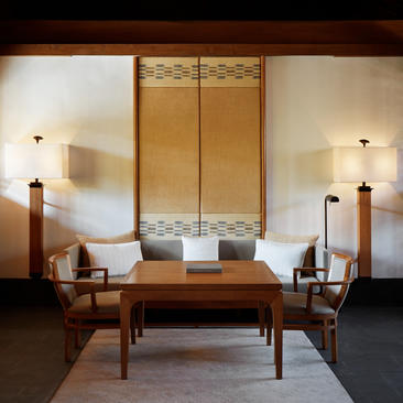 Living area of the Deluxe Suite at Amandayan, featuring wooden furniture and soft lighting.