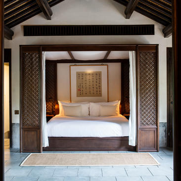 法云安缦度假村卧室，配有四柱床和木质天花板。