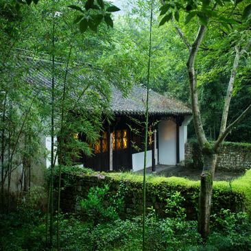 法云安缦度假村中的村舍套房，建筑坐落于林间，周围被绿色植被环绕。