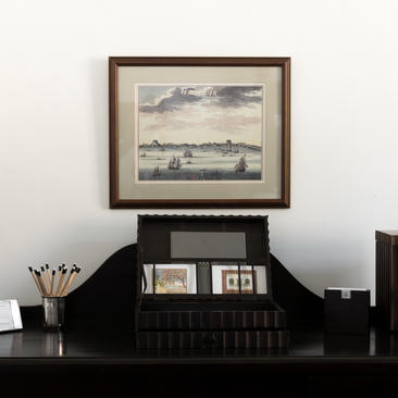 Framed landscape artwork above a black desk with decorative objects at Amangalla.
