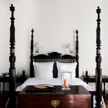 Principal bedroom at Amangalla with four-poster bed and white linens.