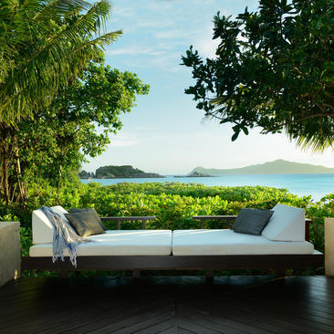 Villa terrace with sofa overlooking tropical bay at Amanpulo resort, Palawan.