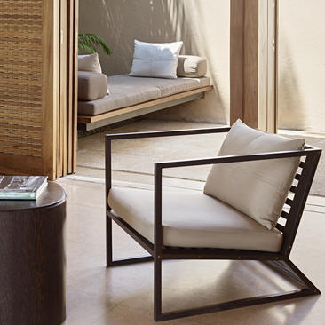 Amanwella suite interior with geometric armchair and alcove seating nook.