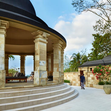 Dalem Jiwo Suite pavilion with stone columns and steps at Amanjiwo, surrounded by lush gardens.