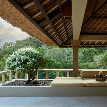 Garden Suite terrace at Amankila with views across tropical landscaping and hillside.