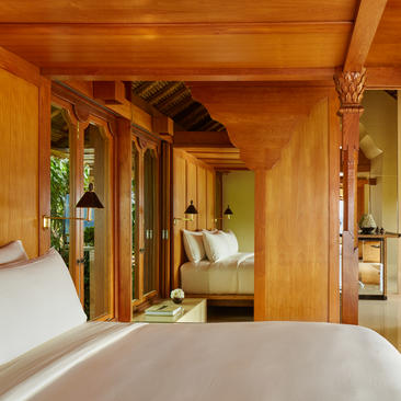 Suite bedroom with wooden architecture and open-plan living at Amankila resort.