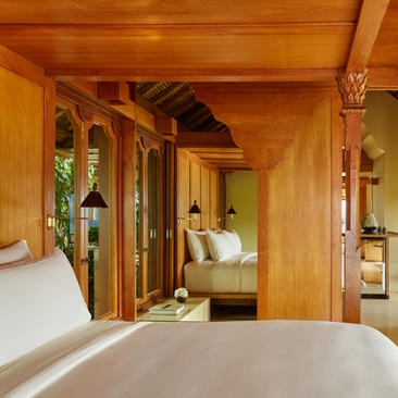 Suite bedroom at Amankila with wooden pavilion architecture and garden views.