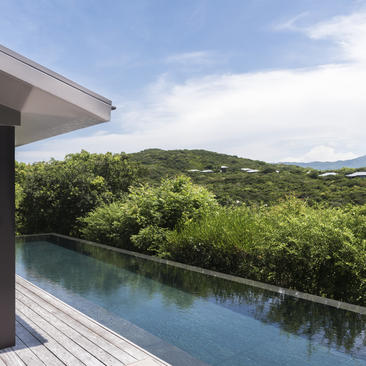 Infinity pool terrace overlooking forested hillside at Amanoi.