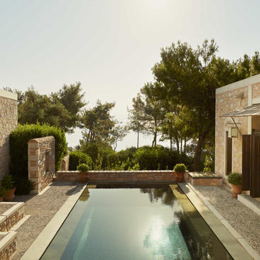 Amanruya sea view pavilion with rectangular plunge pool and stone architecture nestled amongst Mediterranean greenery.