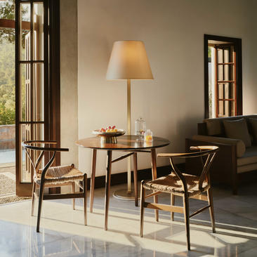 Living room in a Garden View Pavilion at Amanruya, featuring wooden furniture and warm lighting.
