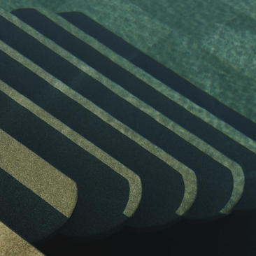 Amanruya pool with curved architectural lines casting shadows across still water.