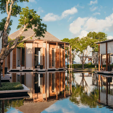 Pool terrace at Amanyara with wooden pavilions reflected in still water, Turks and Caicos.