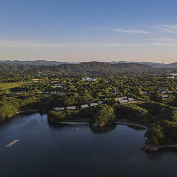 Aerial view of Amanemu resort nestled amongst forested hills and waterside landscape in Japan.
