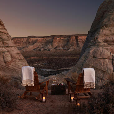 Amangiri resort's outdoor bath pavilion nestled beneath towering red rock formations at dusk.