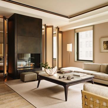 Suite angolare con zona living, camino e arredamento minimalista all'Aman New York.