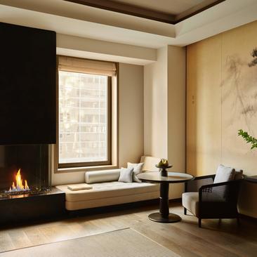 Fifth Avenue Junior Suite with fireplace, window seat, and minimalist furnishings at Aman New York.
