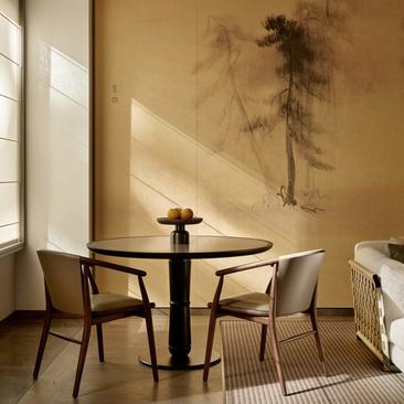 Sala d'attesa con tavolo rotondo e due sedie presso Aman New York, hotel.