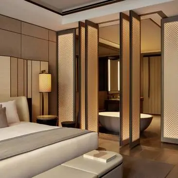 Premier Sanctuary Suite at Aman New York with wooden wardrobe and neutral furnishings.