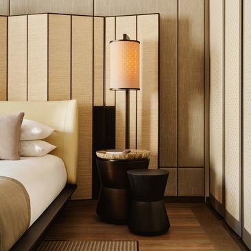 Suite Premier con letto queen, comodini in legno scuro e lampada in legno presso Aman New York.