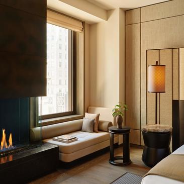 Principal bedroom window seat with fireplace at Aman New York, overlooking 57th Street.