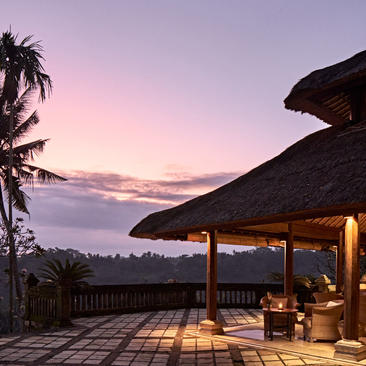 منصة مضاءة في منتجع أمانداري بإندونيسيا عند الغسق، تطل على المناظر الطبيعية البعيدة.
