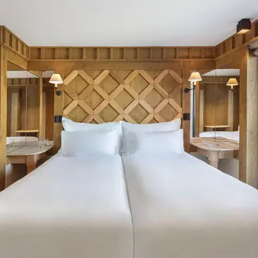 Chambre Junior avec lit double et boiseries dorées à Aman Le Mélézin.