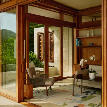 Sala de estar con puertas de madera y vistas al jardín en Amanera Resort.