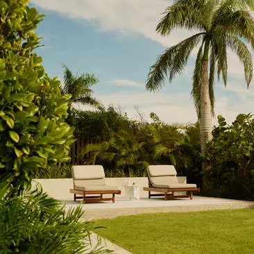 Casita terrace with lounge seating overlooking manicured gardens and palm trees at Amanera resort.