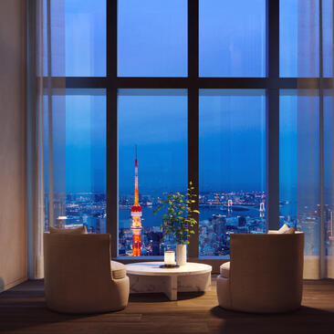 Two chairs facing floor-to-ceiling windows overlooking Tokyo's illuminated skyline at dusk, Amanyangyun residences.