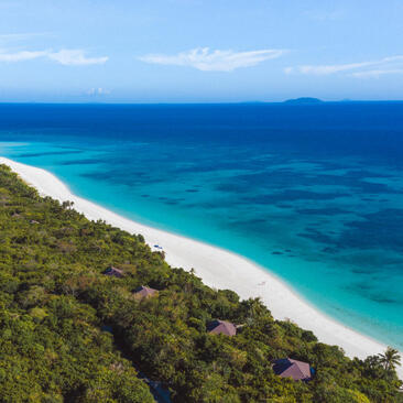 Aerial view of Pamalican Island's white sand beach and turquoise waters at Amanpulo.