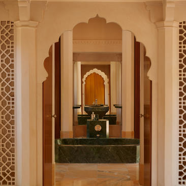 Bathroom at Amanbagh with arched doorway, marble basin and traditional Indian architectural details.
