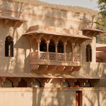 Exterior of a Terrace Haveli Suite at Amanbagh, showcasing traditional carved stone balcony and arched openings.