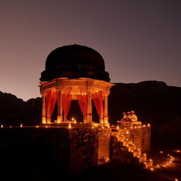 Chhatri monument illuminated in orange at dusk, Amanbagh.