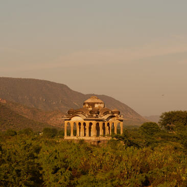 Neoclassical pavilion illuminated at dusk in the Aravalli hills at Amanbagh.