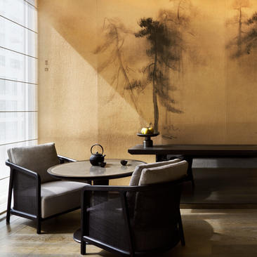 Deluxe suite sitting area at Aman New York with black furniture and abstract wall art.