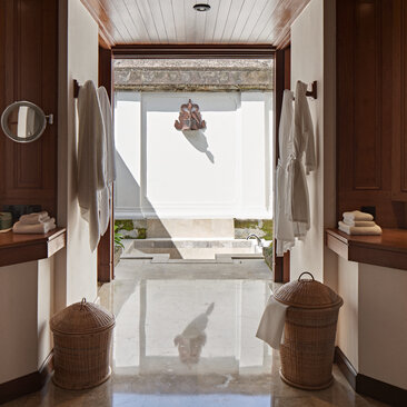 Duplex pool suite bathroom at Amandari with dual vanities, marble flooring, and view to terrace beyond.