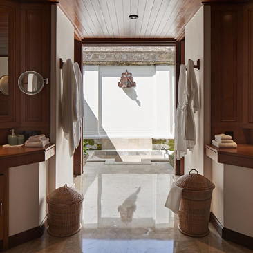 Bathroom at Amandari with dual vanities, wooden panelling, and open doors revealing a plunge pool overlooking the landscape.