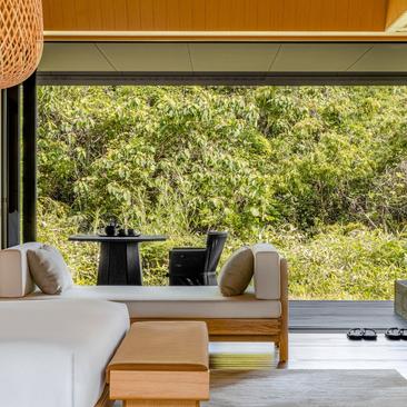 Mori Suite bedroom at Amanemu with garden views, featuring wooden panelling and contemporary furnishings.